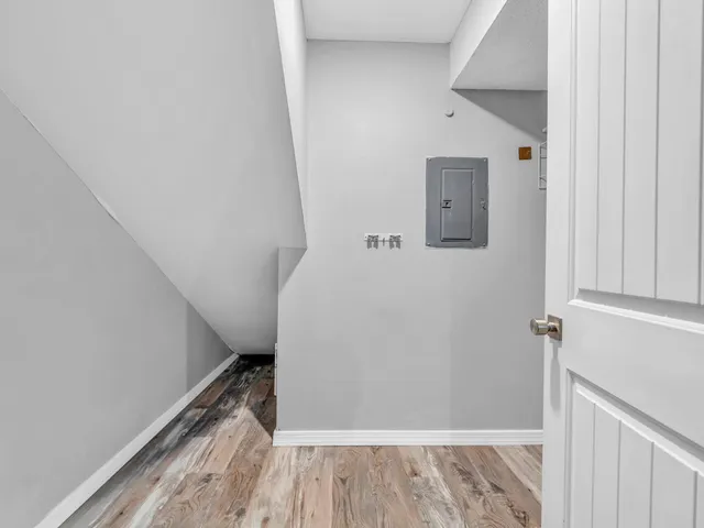 a view of a hallway with wooden floor and staircase