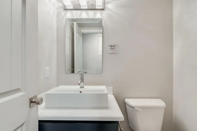 a bathroom with a sink a toilet and mirror