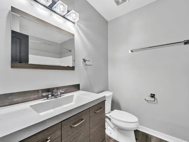 a bathroom with a sink a toilet a mirror and vanity