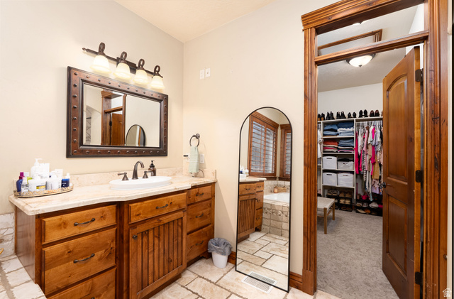 687 South 2080th Street East Springville, UT 84663 - Photo 19 of 149 Bathroom featuring a spacious wood vanity with a light-colored countertop and undermount sink, bronze-finish fixtures, and a framed mirror