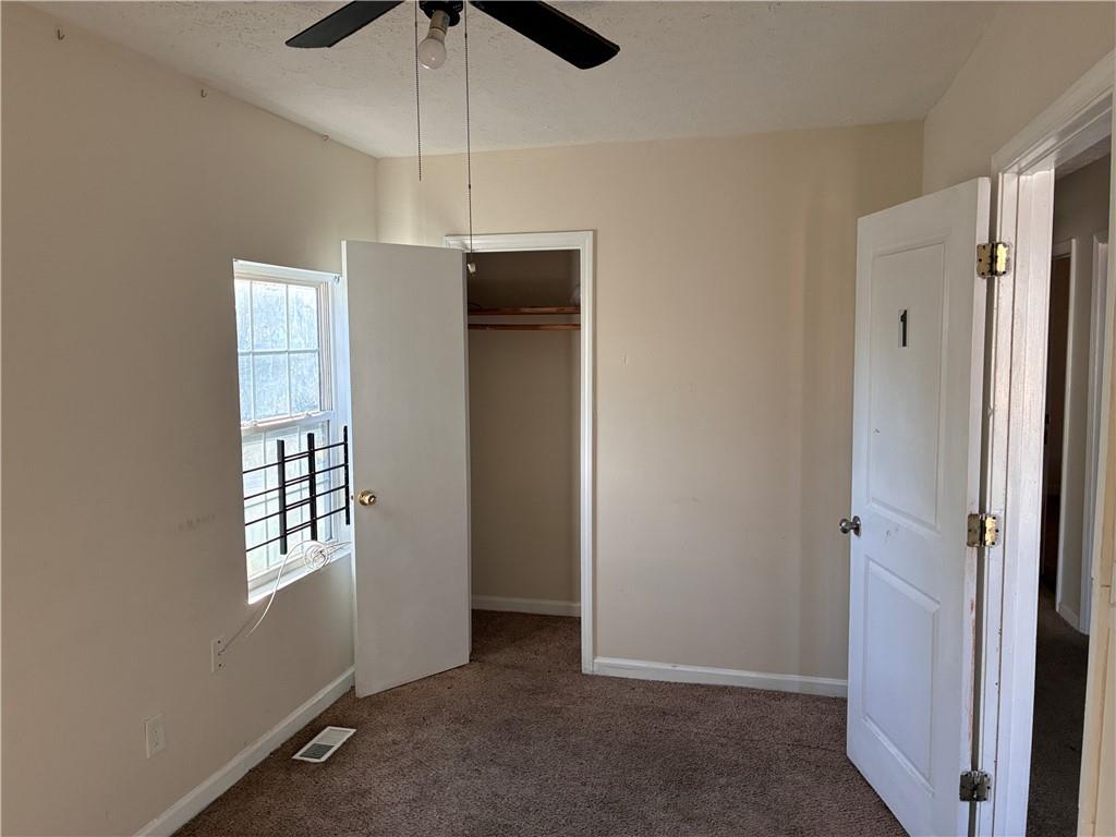 856 Beckwith Street Southwest Atlanta, GA 30314 - Photo 7 of 19 an empty room with windows and ceiling fan