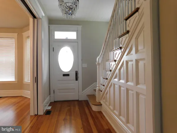 a view of a hallway with wooden floor and staircase