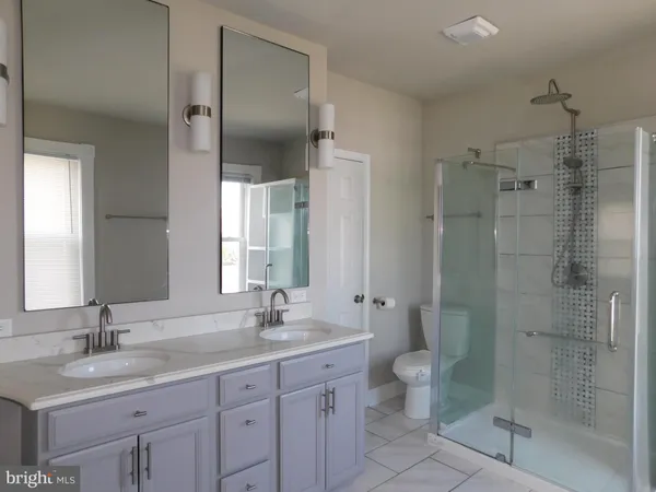 a bathroom with a granite countertop sink toilet and shower