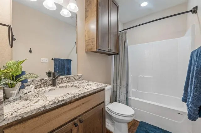 a bathroom with a granite countertop sink toilet and shower