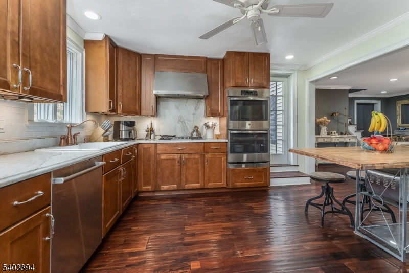 18 Sanatorium Road Glen Gardner, NJ 08826 - Photo 5 of 31 a kitchen with stainless steel appliances a stove a sink dishwasher a microwave oven and a dining table with wooden floor