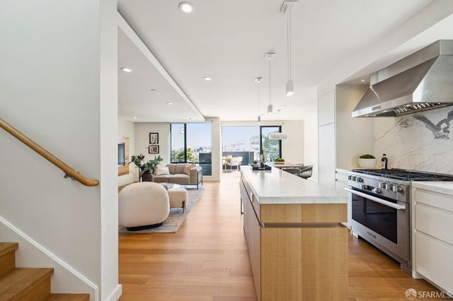 a view of a kitchen with kitchen island stainless steel appliances sink stove and cabinets