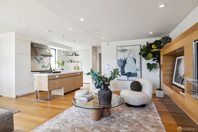 a room with kitchen island stainless steel appliances living room and a couch