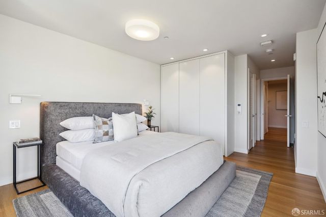 a spacious bedroom with a bed and a rug