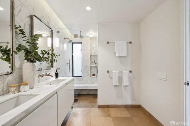 a bathroom with a double vanity sink a mirror and a shower
