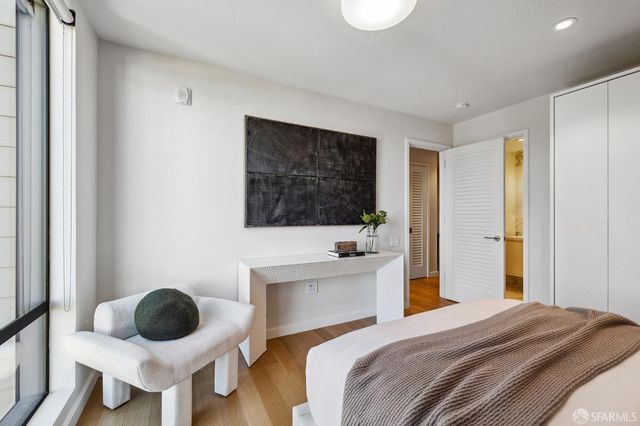 a bedroom with a bed a window and cabinets