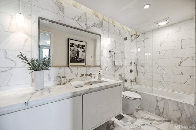 a bathroom with a double vanity sink toilet and shower