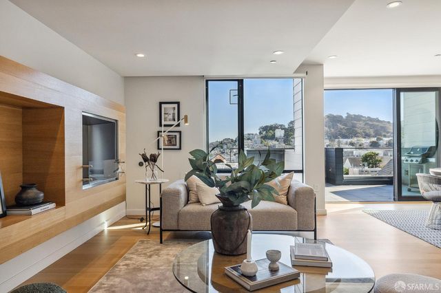 a living room with furniture potted plant and a large window