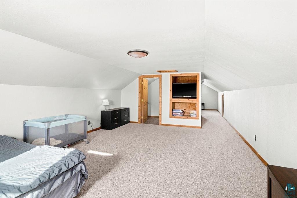 3949 East County Rd B Superior, WI 54880 - Photo 37 of 50 Carpeted room featuring a built-in media center with wood-finish shelving, sloped ceilings, and recessed lighting