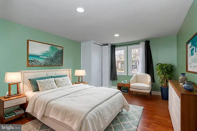 a spacious bedroom with a bed a couch and a potted plant