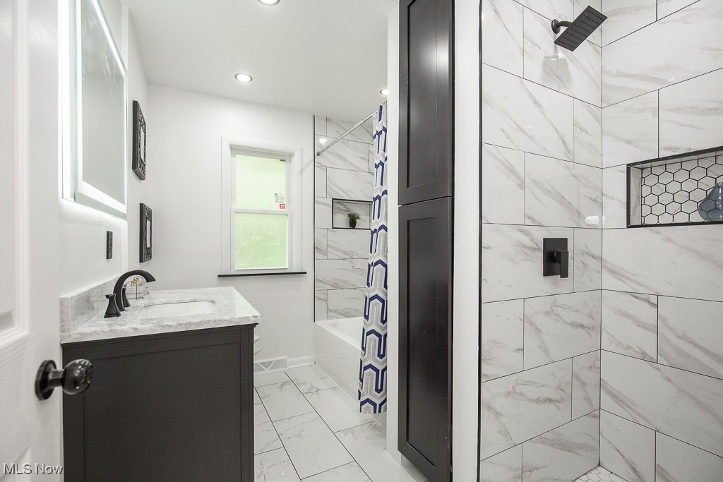 22210 Emery Road Cleveland, OH 44128 - Photo 23 of 32 Full bath with vanity, marble look tile flooring, shower combination, and recessed lighting