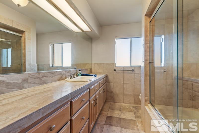 2250 Foothill Road Reno, NV 89511 - Photo 18 of 37 a bathroom with a granite countertop sink a mirror and shower