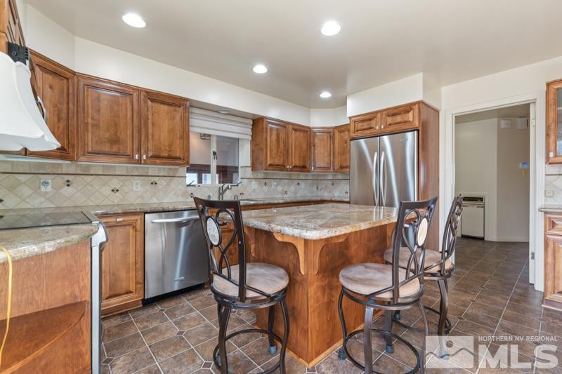 2250 Foothill Road Reno, NV 89511 - Photo 9 of 37 a kitchen with stainless steel appliances granite countertop a table chairs sink and refrigerator
