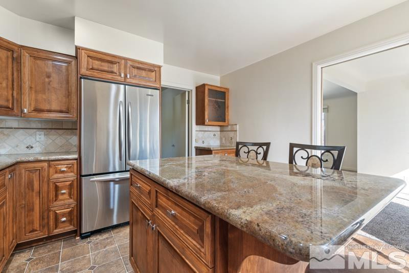 2250 Foothill Road Reno, NV 89511 - Photo 10 of 37 a kitchen with stainless steel appliances granite countertop a refrigerator a stove and a sink with large countertops