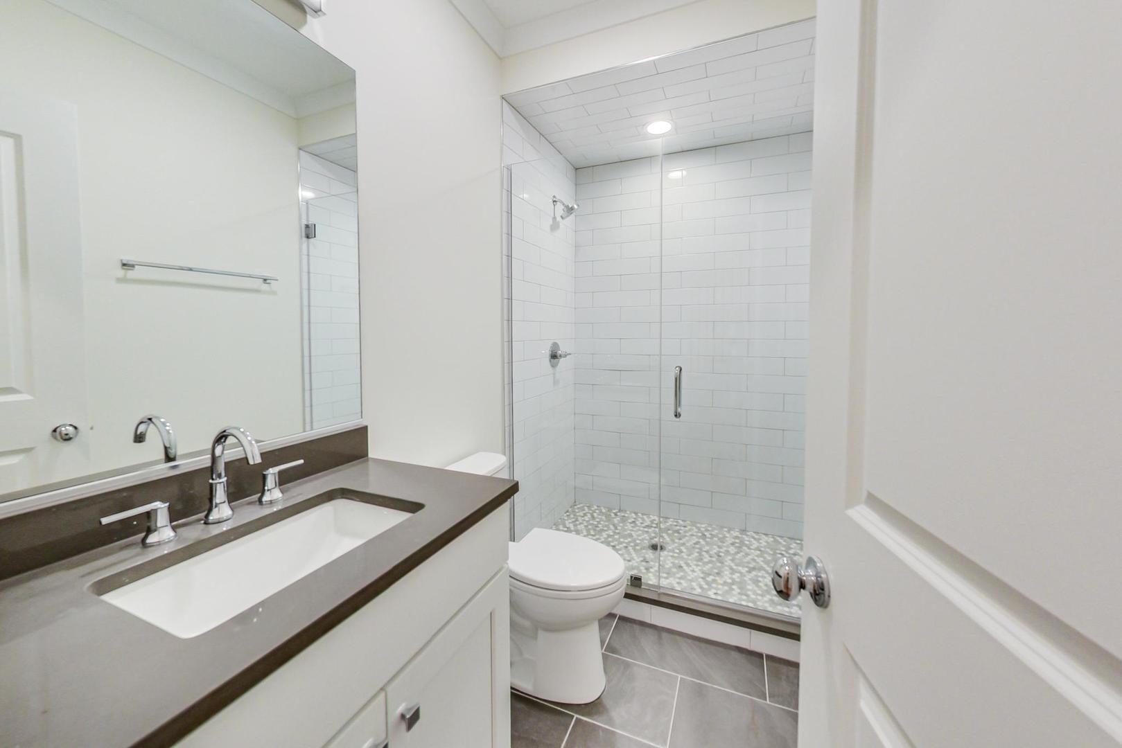 4311 North Western Avenue, Unit 1 Chicago, IL 60618 - Photo 14 of 18 a bathroom with a sink a toilet and shower