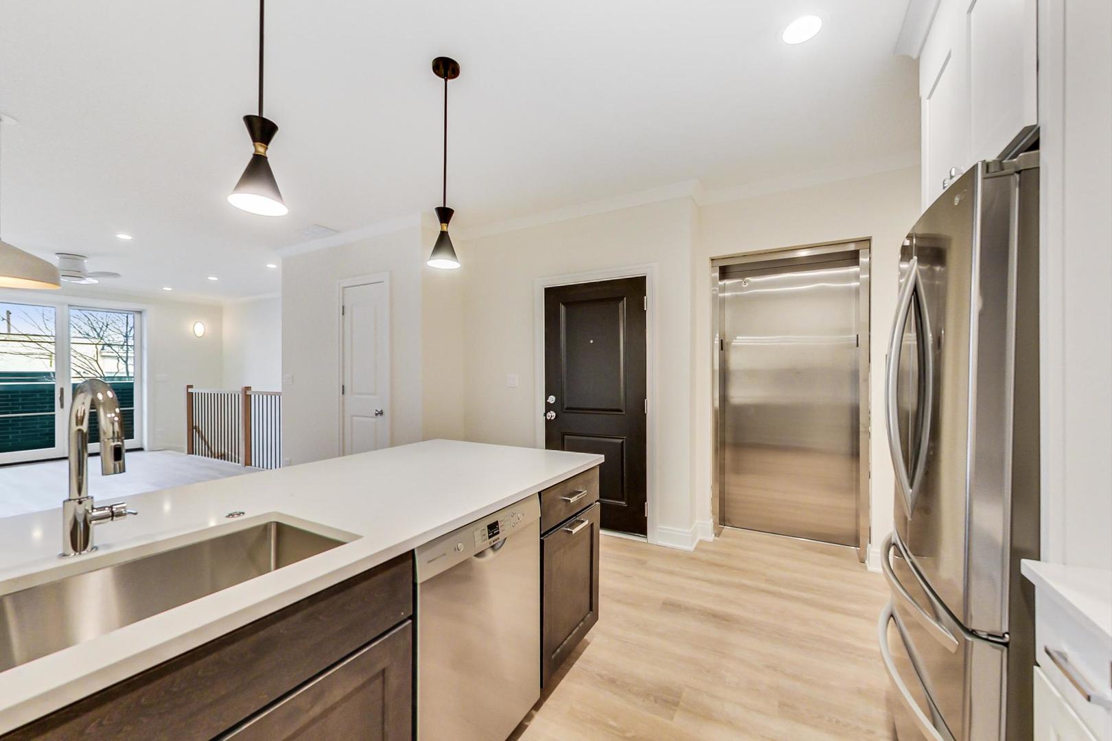 4311 North Western Avenue, Unit 1 Chicago, IL 60618 - Photo 3 of 18 a large kitchen with a refrigerator a sink and a large mirror