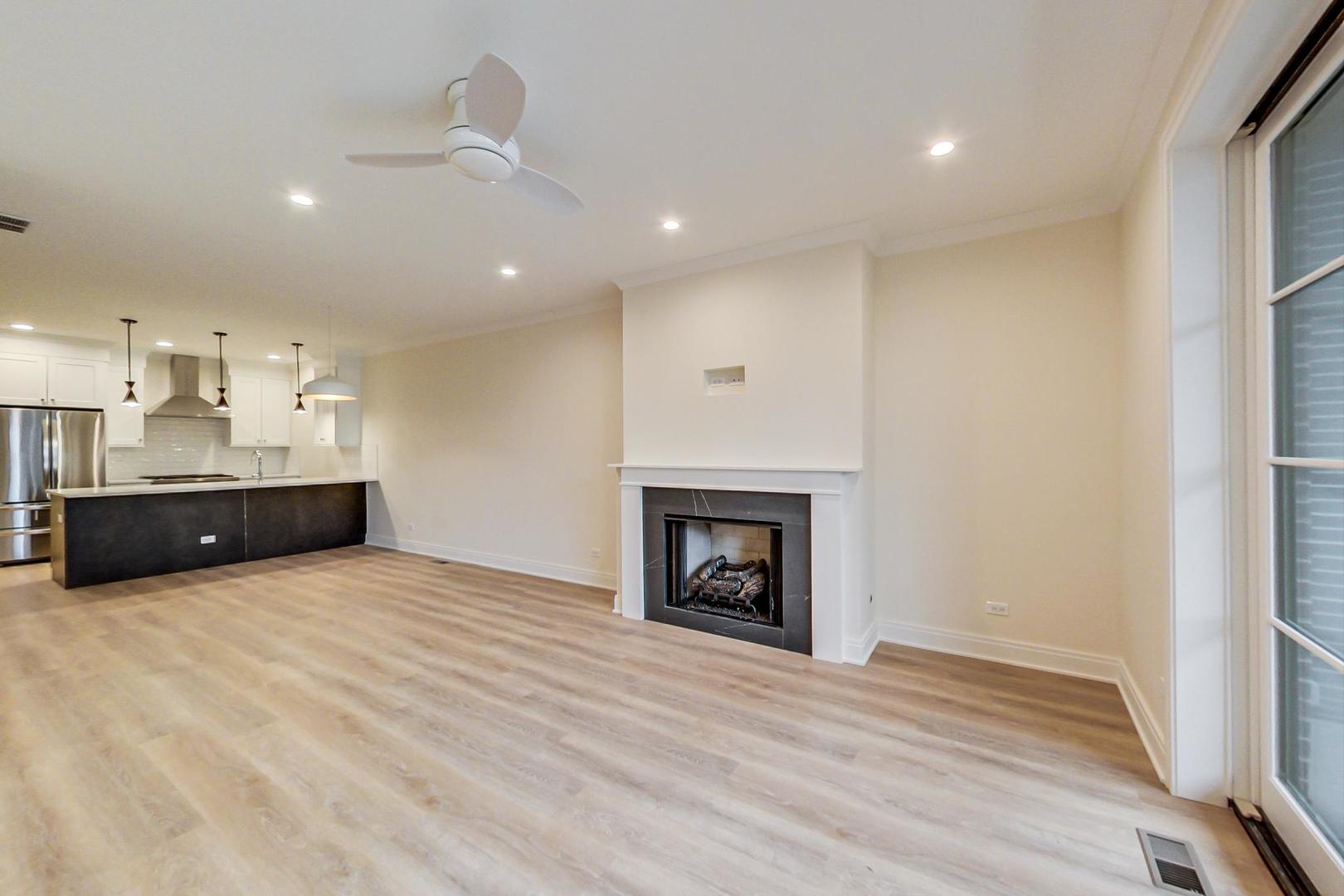 4311 North Western Avenue, Unit 1 Chicago, IL 60618 - Photo 8 of 18 a view of an empty room with a fireplace and a window