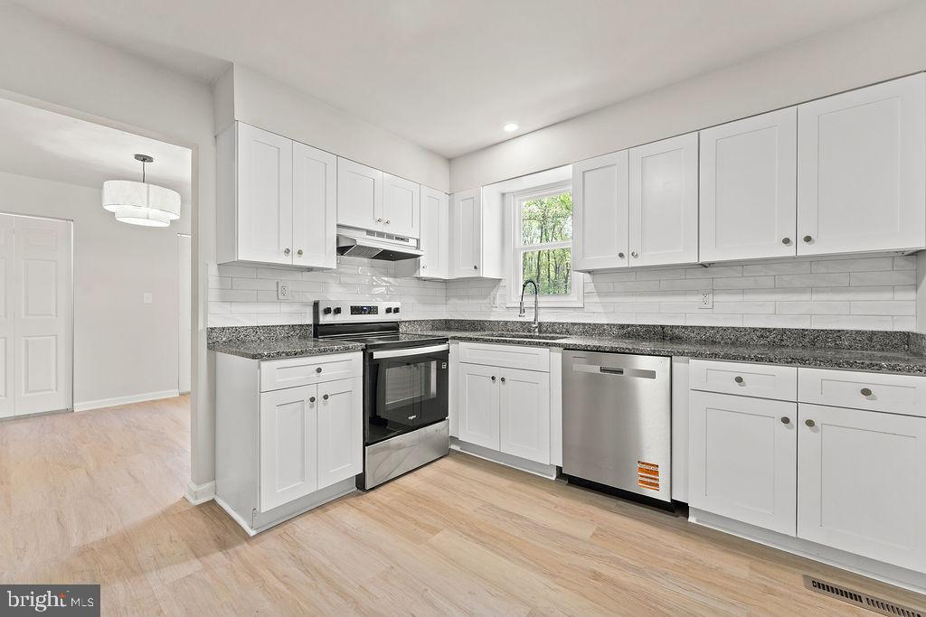 28494 Eddings Road Rhoadesville, VA 22542 - Photo 13 of 32 a kitchen with granite countertop white cabinets and white appliances