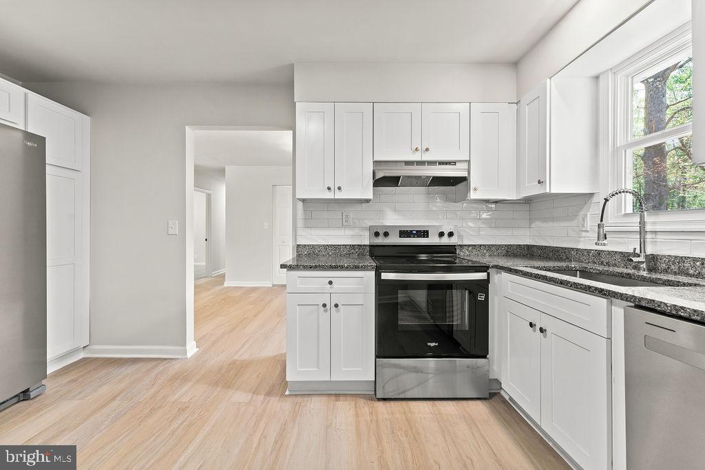 28494 Eddings Road Rhoadesville, VA 22542 - Photo 14 of 32 a kitchen with stainless steel appliances granite countertop a stove and white cabinets