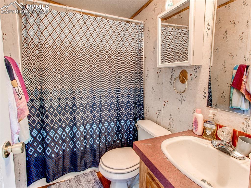4491 Lauppe Road Yoder, CO 80864 - Photo 14 of 27 a white toilet sitting next to a bathroom sink