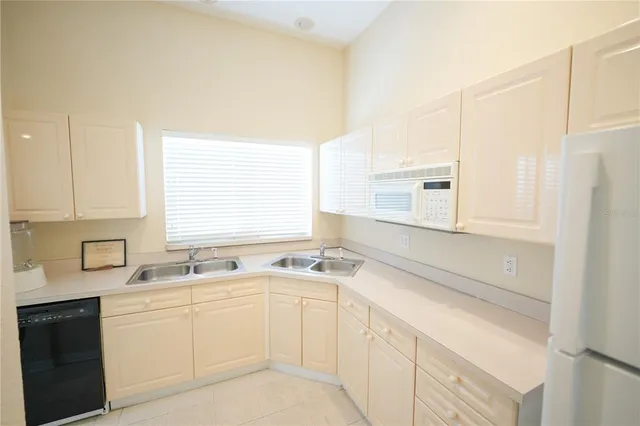 a kitchen with a sink cabinets appliances and a window