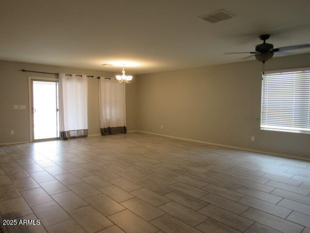 17164 West Straight Arrow Lane Surprise, AZ 85387 - Photo 15 of 39 an empty room with windows and a chandelier