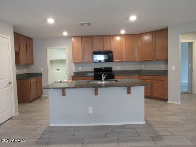 17164 West Straight Arrow Lane Surprise, AZ 85387 - Photo 24 of 39 a kitchen with kitchen island granite countertop a stove a sink a refrigerator and a oven