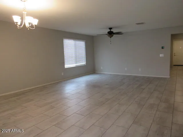 an empty room with a window and a ceiling fan