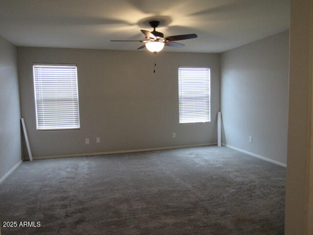 17164 West Straight Arrow Lane Surprise, AZ 85387 - Photo 4 of 39 an empty room with a window and a ceiling fan