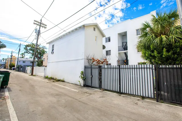 a view of a house with a yard and potted plants