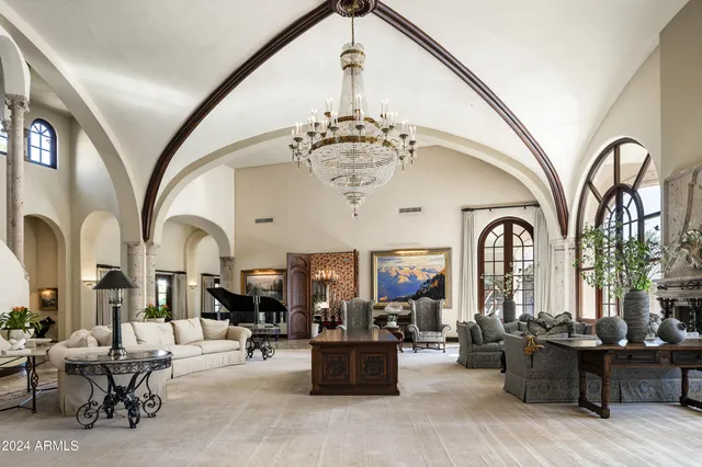 a living room with furniture floor to ceiling window and wooden floor