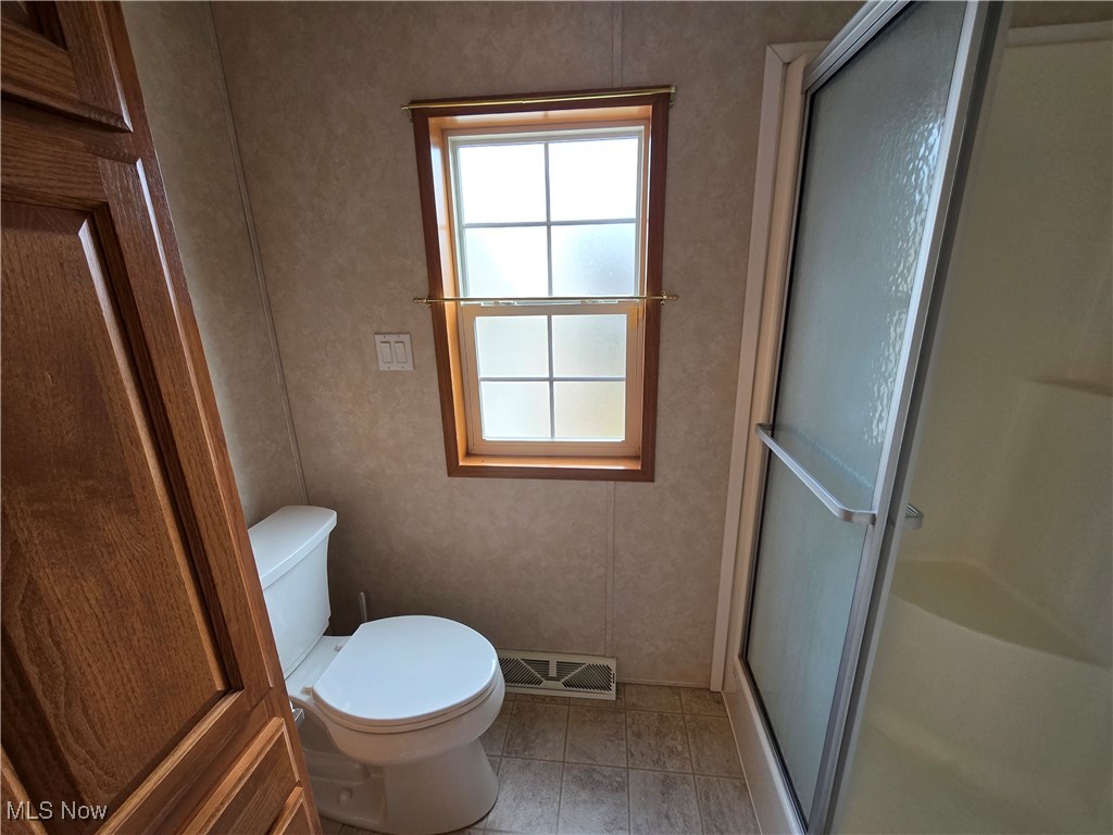 450 Beeman Road Washington, WV 26181 - Photo 17 of 24 Bathroom with tile patterned floors, a shower with door, and toilet
