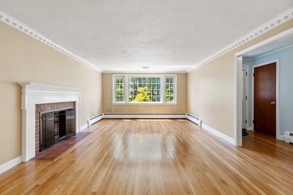 29 Gregory Road Wakefield, MA 01880 - Photo 8 of 29 an empty room with wooden floor fireplace and windows