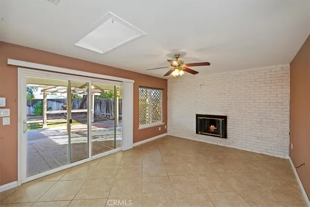 a view of an empty room with a fireplace and a large window