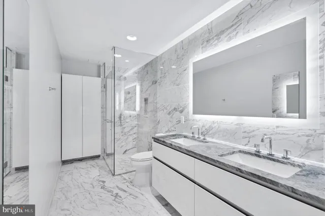 a bathroom with a granite countertop sink a mirror and a shower