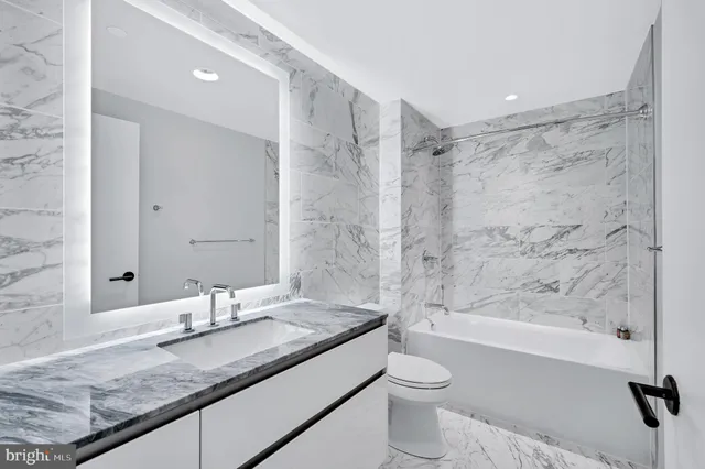a bathroom with a granite countertop sink toilet and shower