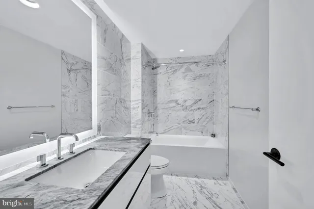 a bathroom with a granite countertop bathtub shower sink and mirror