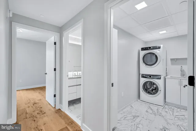 a view of a hallway with wooden floor and a bathroom