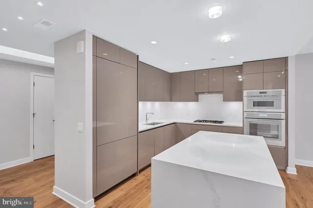 a kitchen with a refrigerator a sink and a stove top oven