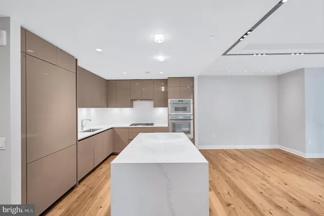 a view of kitchen with stainless steel appliances cabinets and wooden floor