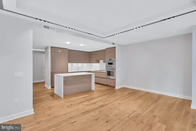 a kitchen with a refrigerator and white cabinets