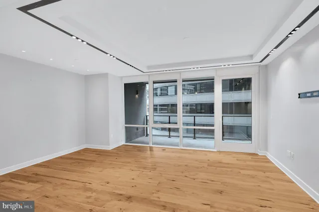 a view of empty room with wooden floor and windows