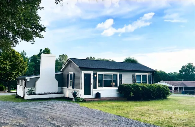 a front view of a house with a garden and yard