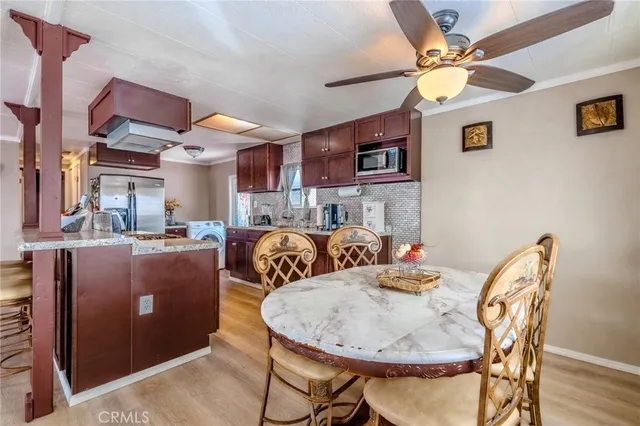 a view of a dining room with furniture and a chandelier fan