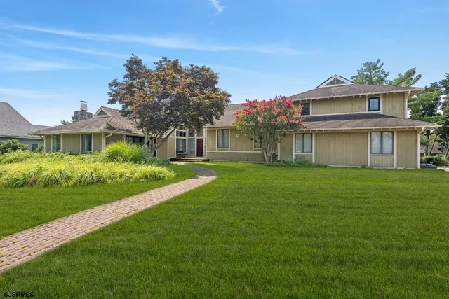 a front view of a house with a garden and yard