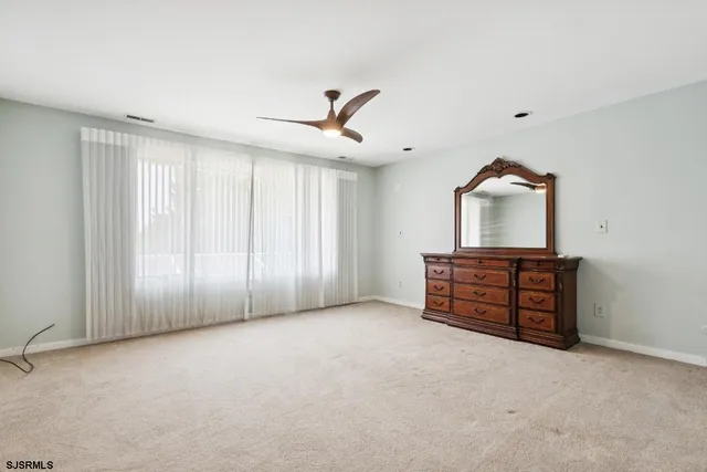 an empty room with windows and cabinet